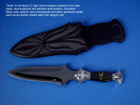 "Vesta" Dagger, obverse side view in hot-blued O1 high carbon tungsten-vanadium tool steel blade, hand-engraved 304 stainless steel bolsters, Australian Black Jade and Apache Gold (chrysopyrite and slate) gemstone handle, hand-carved leather sheath inlaid with stingray skin